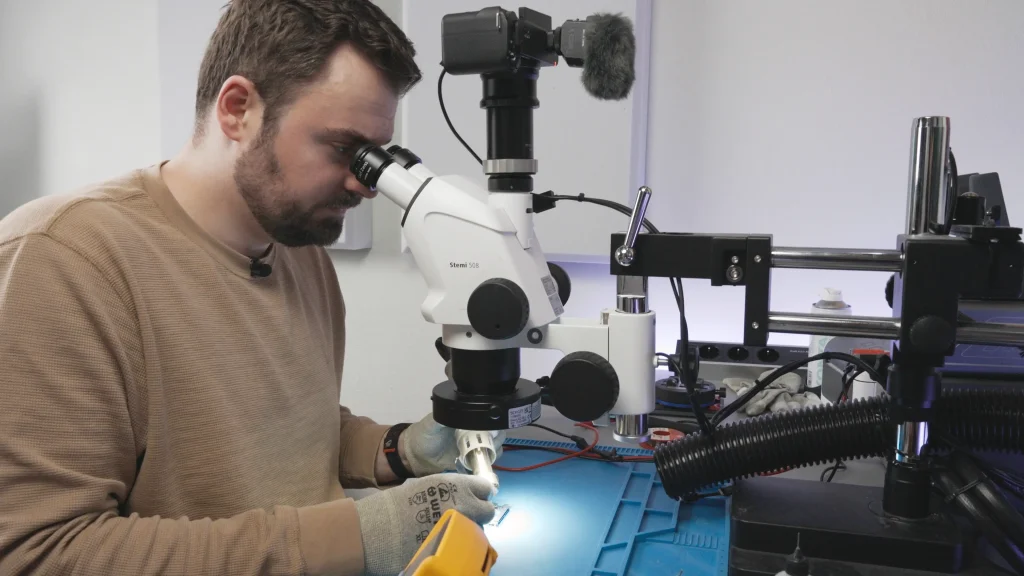 Smartronik Experte bei der Microsoldering Reparatur unter dem Mikroskop